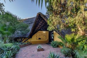 an exterior view of a house with a brick patio at Protea Hotel by Marriott Lusaka Safari Lodge in Chisamba