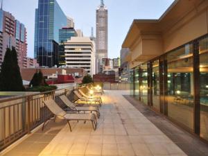 un grupo de bancos sentados en un balcón del edificio en HeartCBD LUX Top Floor 2 Bedroom /Pool/Spa/GYM, en Melbourne