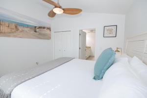 a bedroom with a white bed with a blue pillow at Sparkling & Spacious - Waterfront - 2bd,2ba - Sleeps 8 in Fort Pierce