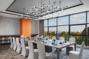 a conference room with a long table and white chairs at Four Points by Sheraton Shanghai Hongqiao in Shanghai