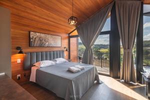 a bedroom with a bed and a large window at CABANAS LE VIGNE in Pinto Bandeira