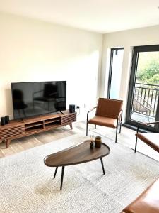 a living room with a large flat screen tv at Luxury Furnished Apartment in Heart of Quincy in Quincy