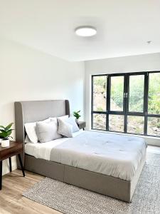 Un dormitorio blanco con una cama grande y una ventana en Luxury Furnished Apartment in Heart of Quincy, en Quincy