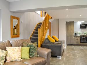 a living room with a couch and a staircase at Stoney Wall-uk45045 in Greenhead