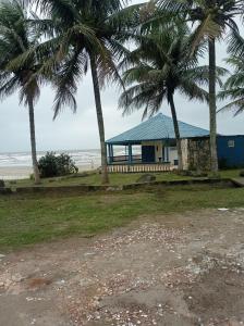 a house with palm trees in front of the beach at Casa de praia Melo in Itanhaém