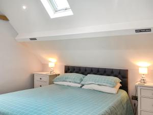 a bedroom with a blue bed with two lamps at Stoney Wall-uk45045 in Greenhead