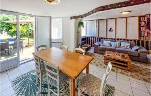 een woonkamer met een houten tafel en stoelen bij Amazing Home In Les Sables Dolonne With Kitchen in Saint-Martin-de-Brem
