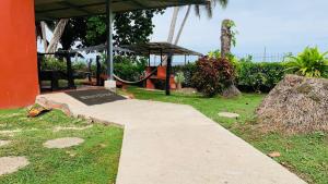 a concrete walkway with a sign in the grass at Hotel Cabinas Mar Y Cielo in Montezuma