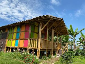 a small house with a rainbow colored facade at Finca Cafetera Madrigal - Café Sortiz in Maravélez