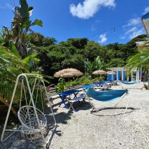 a group of chairs and umbrellas on a beach at Guest House Churaumi in Shimoda