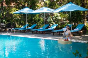 a woman standing in the water next to a swimming pool at Bai Dinh Garden Resort & Spa in Ninh Binh