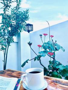 マニラにあるCrosswinds Hotelの植物のあるテーブルに座ってコーヒーを飲む
