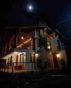 Ein Haus in der Nacht mit dem Mond am Himmel in der Unterkunft Acogedora villa en Jamaca de Dios, Jarabacoa in Jarabacoa