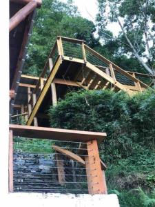 eine Holztreppe, die zu einem Gebäude mit Gras führt in der Unterkunft Acogedora villa en Jamaca de Dios, Jarabacoa in Jarabacoa