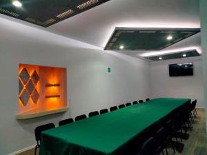 einen Konferenzraum mit einem grünen Tisch und Stühlen in der Unterkunft HOTEL PLAZA PACHUCA in Zapotlán de Juárez
