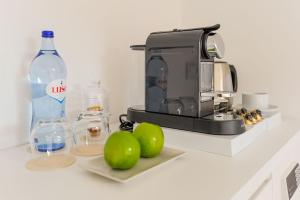 a kitchen counter with a coffee maker and two green apples at Boutique Room Montijo in Montijo