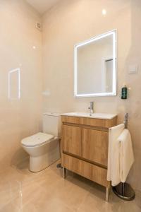 a bathroom with a toilet and a sink and a mirror at Boutique Room Montijo in Montijo