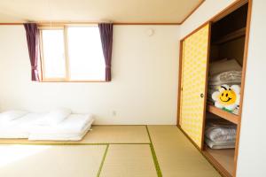 Habitación con 2 camas y ventana en Ezo Fujiya Niseko House, en Kutchan