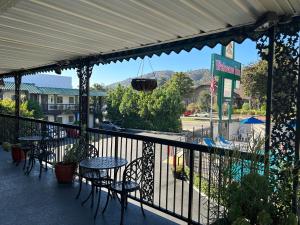 a patio with tables and chairs and a balcony with a view at Welcome Inn in Los Angeles