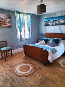 una camera da letto con un letto grande e una sedia di L'esprit de famille a Semur-en-Auxois