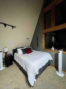 um quarto com uma cama grande e uma janela em Secluded cabin on the water with jet skis, kayaks, & hot tub! Pet friendly em Satsuma