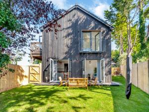 una casa de metal con un patio con una valla de madera en Willow House en Worle