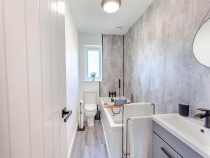 a white bathroom with a toilet and a sink at Willow House in Worle