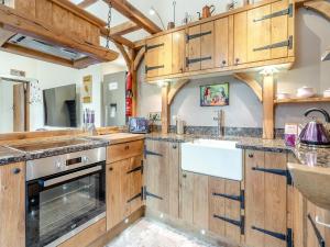 a kitchen with wooden cabinets and a sink at The Chapel - Uk45104 in Hoel-galed