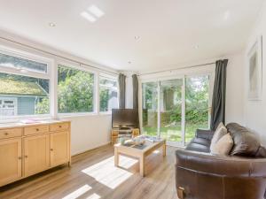 a living room with a couch and some windows at Keepers Wood - W43109 in Bradworthy