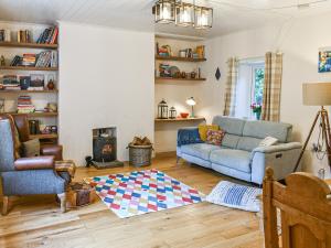 a living room with a couch and a fireplace at Brookside Cottage in Copley