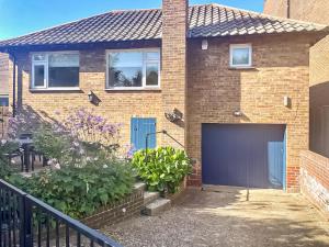 a brick house with a blue garage door at Seaways in Lee-on-the-Solent