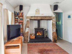 a living room with a fireplace and a tv at No Place in Sennen