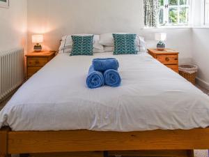 um quarto com uma cama com toalhas azuis em No Place em Sennen