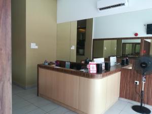 a reception counter in a restaurant with a mirror at The Daily Hotel in Kota Kinabalu