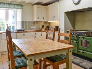een keuken met een houten tafel en een groene oven bij Stoneybeck-uk45044 in Greenhead
