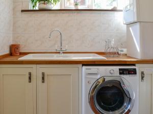 een keuken met een wastafel en een wasmachine bij Stoneybeck-uk45044 in Greenhead