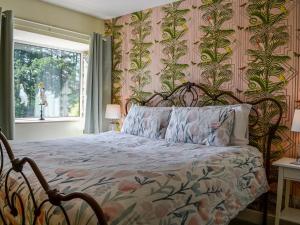 a bedroom with a bed with a floral patterned wall at The Granary - Uk45181 in Newcastleton