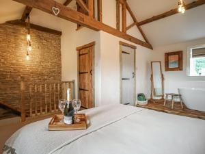Little Badger Cottage في Kirkburton: غرفة نوم بسرير وحمام مع حوض استحمام