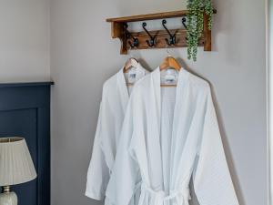 a group of white coats hanging on a rack at Cuckoo Lodge - Uk42541 in Winforton