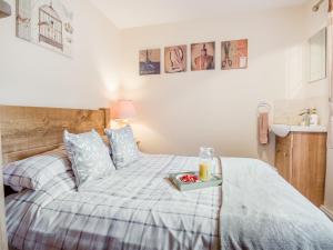 a bedroom with a bed with a tray of fruit on it at Yare Cottage in Reedham