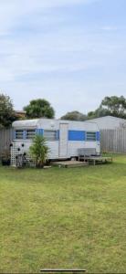 a blue and white trailer parked in a field at OwLHouse on Island in Cowes