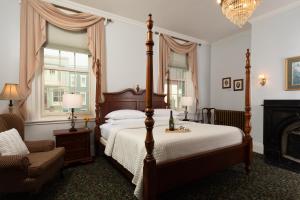 1 dormitorio con 1 cama, 1 silla y chimenea en Carlisle House Bed and Breakfast, en Carlisle