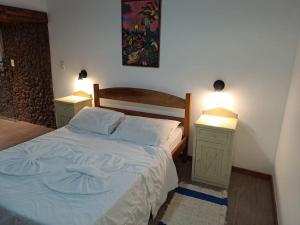 1 dormitorio con 1 cama con 2 mesitas de noche y 2 lámparas en Apartamento Panorãmico Master, en Teresópolis