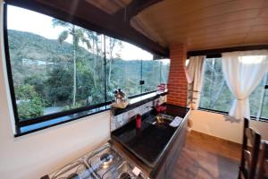 cocina con fogones y ventana grande en Apartamento Panorãmico Master, en Teresópolis