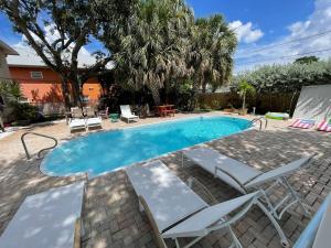 a swimming pool with two lawn chairs and a table and chairs at Sunny Shores Retreat 2 in Clearwater Beach