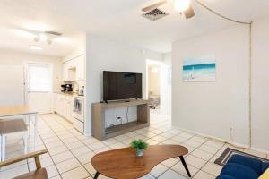 a living room with a couch and a tv and a table at Sunny Shores Retreat 2 in Clearwater Beach