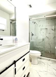 a bathroom with a toilet and a glass shower at Sandy Beach Sunset West in Clearwater Beach