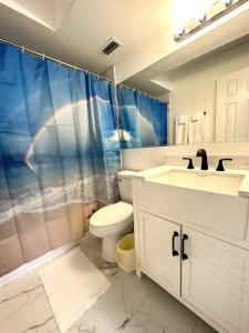 a bathroom with a toilet and a shower and a sink at Sandy Beach Sunset West in Clearwater Beach