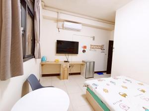 大村鄉的住宿－圓圓民宿，一间卧室配有一张床、一张书桌和一台电视。