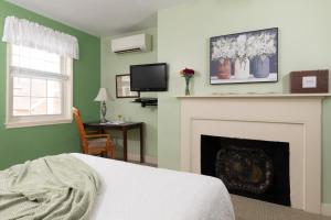 1 dormitorio con chimenea, 1 cama y TV en Carlisle House Bed and Breakfast, en Carlisle